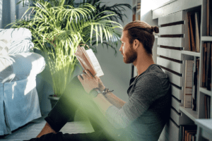 young man sitting outside reading one of many books that empower opiate addiction recovery