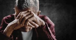 older man with his head in his hands struggling with at-risk alcohol abuse among older people