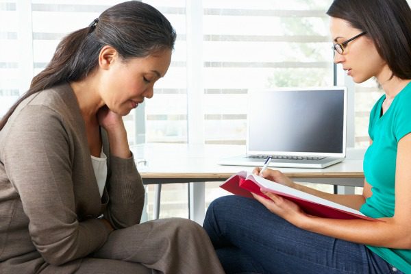 Addicted woman talking to intake counselor