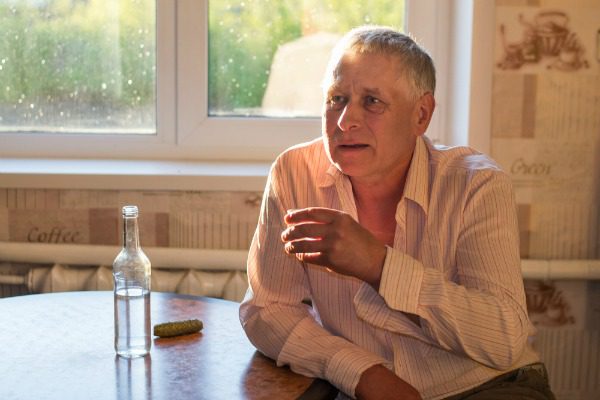 Elderly man drinking vodka