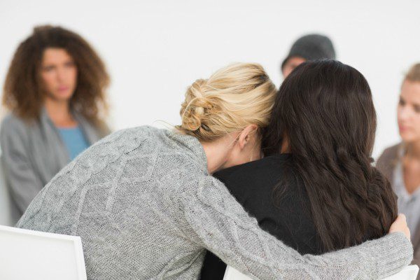 Woman consoling another in counseling session