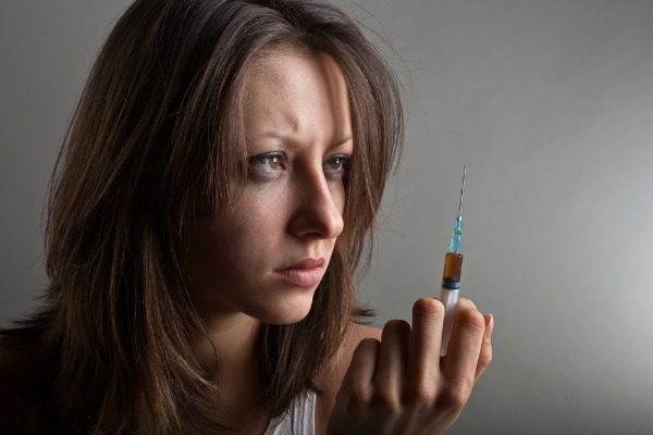 Young woman with heroin needle
