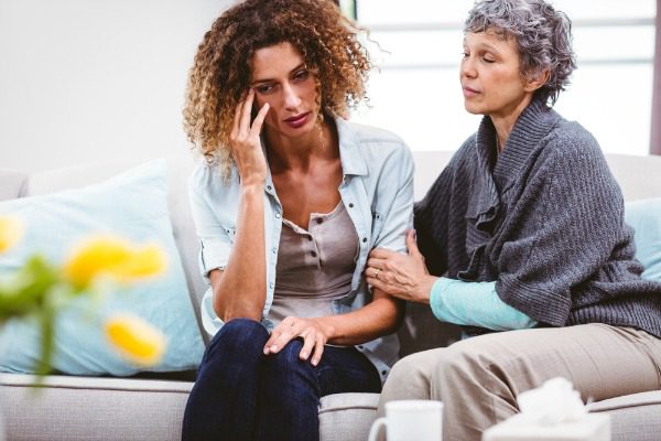 Mother comforting addicted daughter