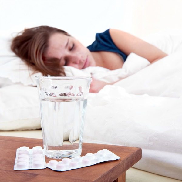 Sleeping woman with Ambien tablets