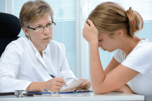 young woman talking to doctor is distraught to learn that 10 percent of patients with painkiller scripts develop addictions