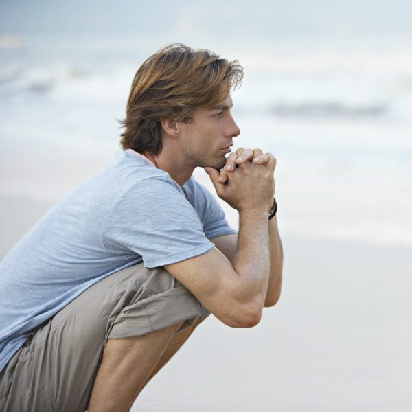 Man practicing mindfulness on the beach