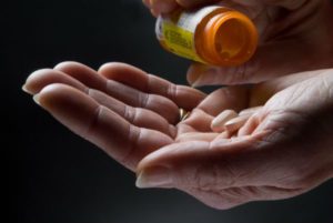 Elderly hand holding pills