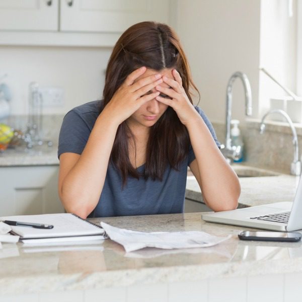 Worried woman with computer and papers