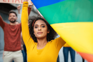 young woman waving rainbow flag representing drug addiction help for the LGBTQ community.