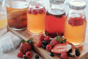 picture of fresh fruit and pitchers filled with fruit juice and tea posing the question can recovering alcoholics drink kombucha