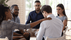 therapist explaining to an aftercare group member what is the role of aftercare in addiction treatment