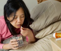 Woman taking sedative in bed