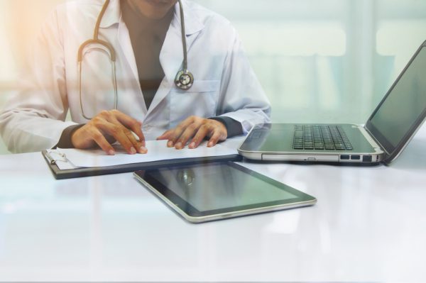 Doctor with laptop and tablet
