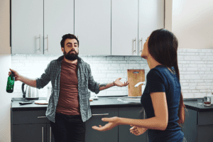 couple having a disagreement in the kitchen over why do those with alcohol addictions lie
