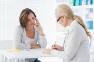 a woman speaks to a doctor about a prescription drug addiction treatment program