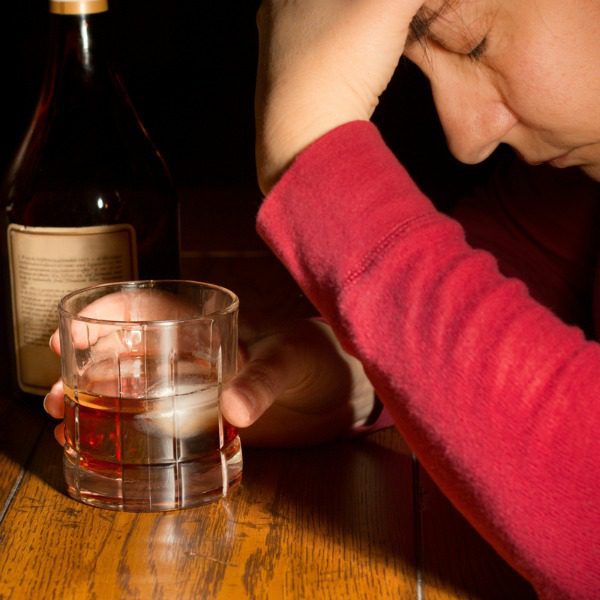 Drunken woman with whiskey glass