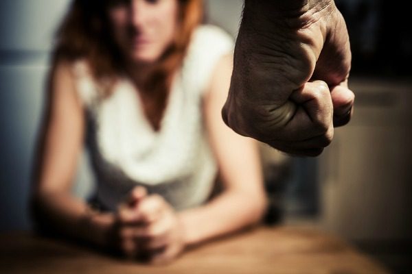 Man's fist threatening woman