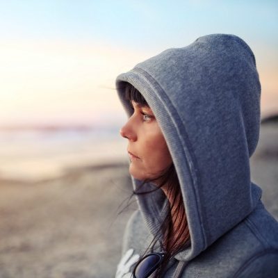 Woman in hoodie on beach