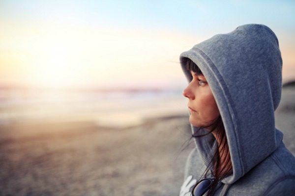 Woman in hoodie on beach