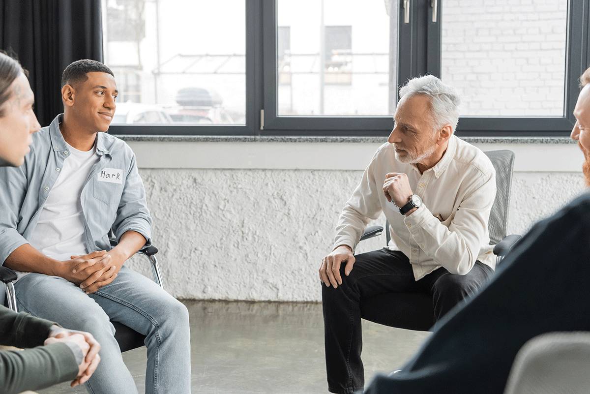 a group member talks during a group therapy session about the differences between inpatient treatment vs. outpatient treatment
