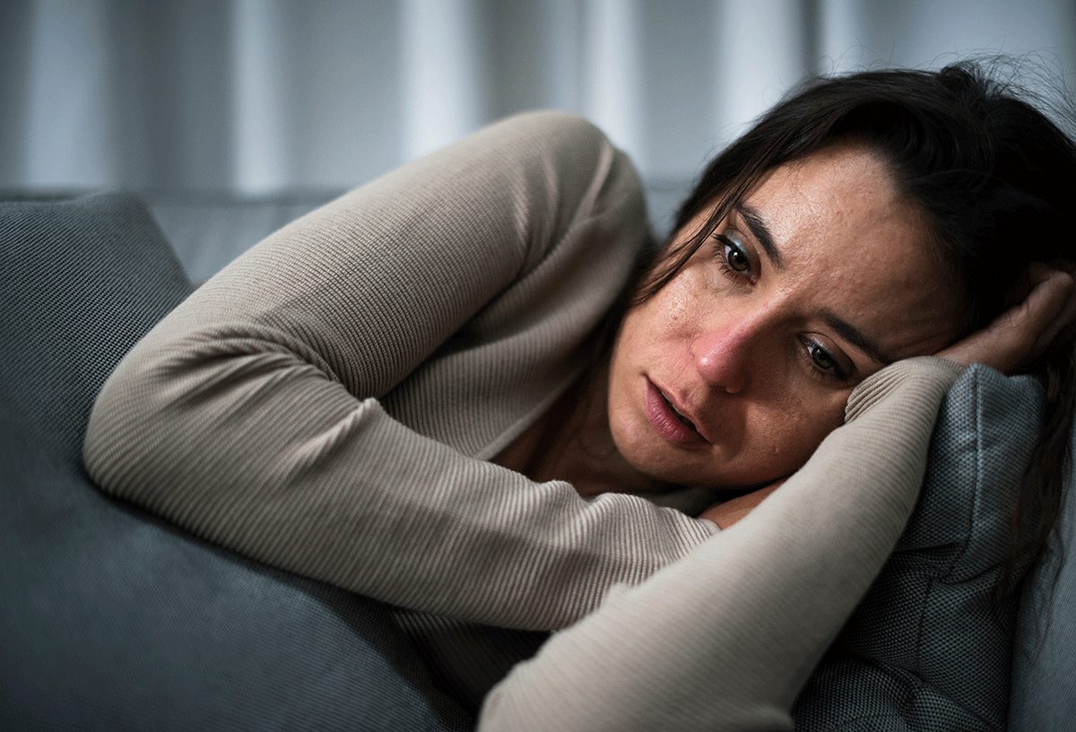 Distraught woman lays down and wonders how to detox from drugs