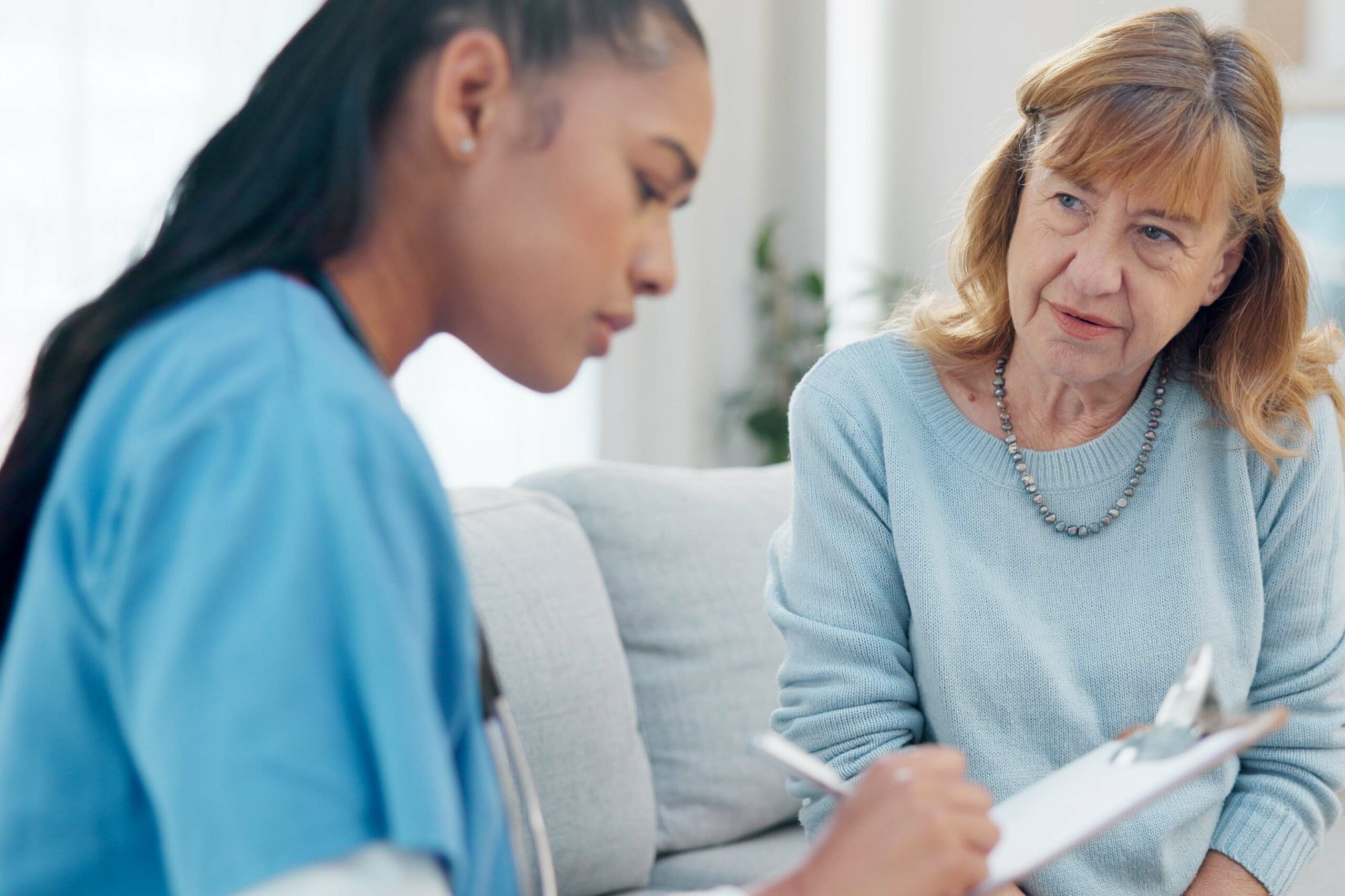 Medical professional writes on a clipboard while a patient asks what is a ciwa score