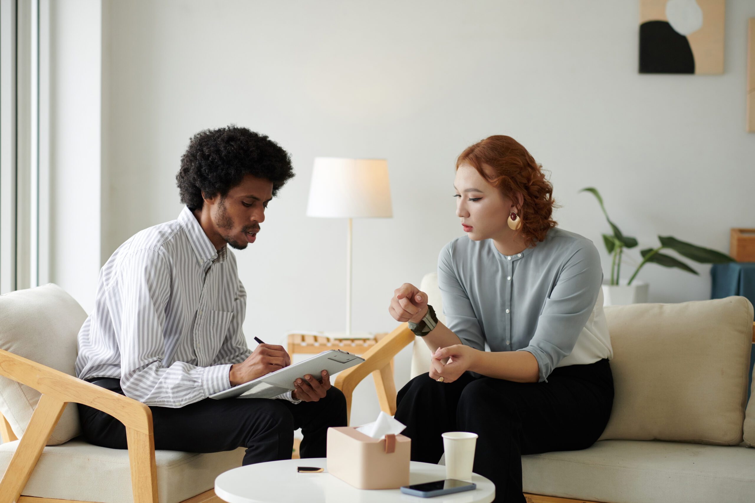 two people sit on chairs looking at a brochure and discussing what is gas station heroin