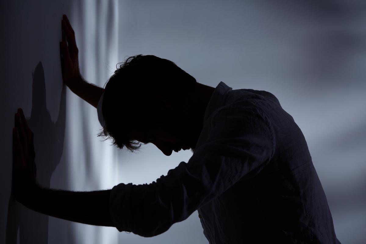 man leans his hands on a wall struggling with the question does cocaine make you aggressive