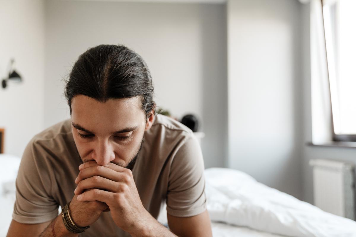 an upset man leans on the edge of his bed asks himself what is poor man's cocaine