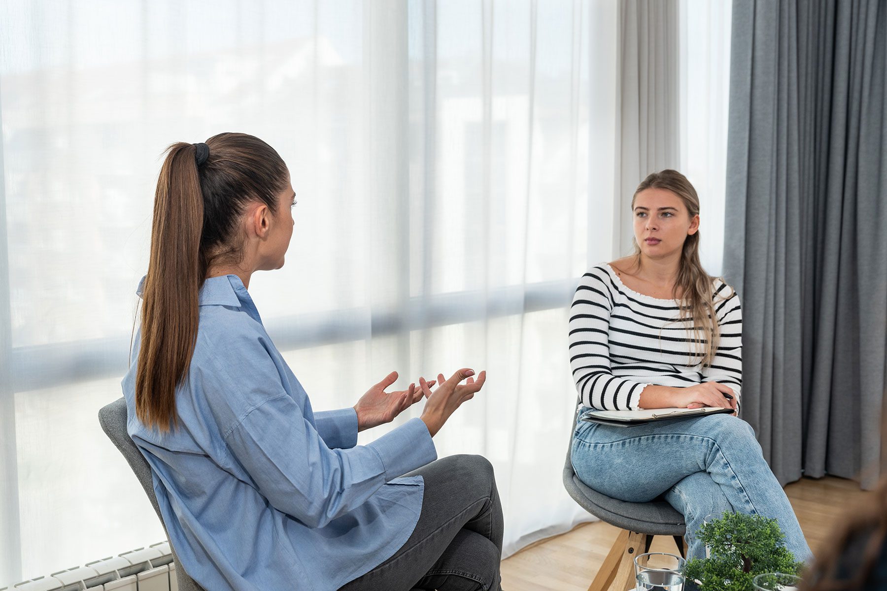 two woman sit together in chairs and discuss the question how long does it take to detox from meth